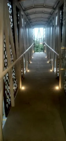 Pasillo exterior techado con balizas de luz embutidas al ras del piso